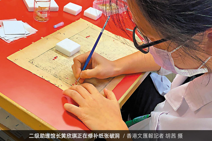 香港中央圖書館二級助理館長黃欣琪正在修補(bǔ)紙張破洞/香港文匯報記者 胡茜 攝